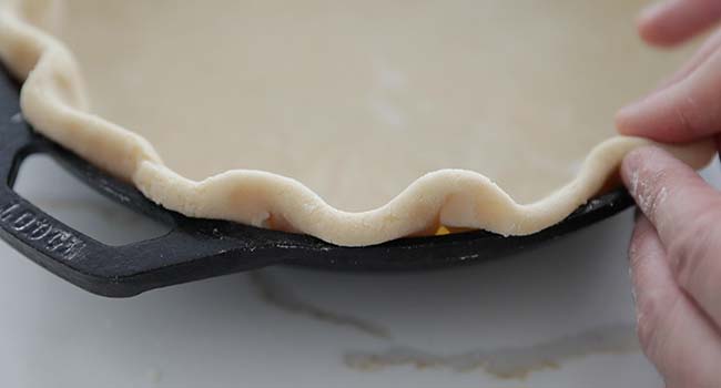 forming a pie crust to a cast iron skillet