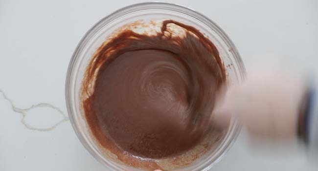 whisking a chocolate batter in a bowl