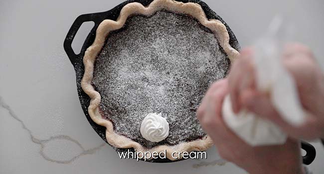 adding whipped cream to a pie