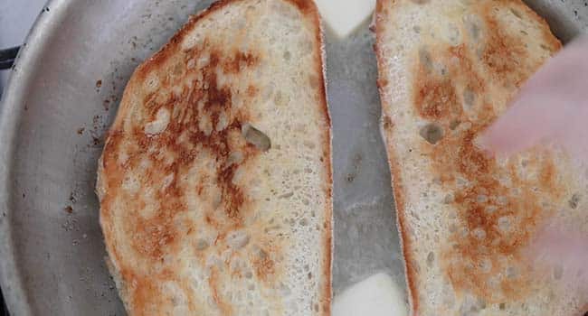 toasting bread with butter in a pan