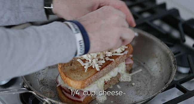 adding shredded Comte cheeses to the top piece of toasted bread