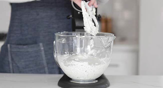 adding herbs to a stand mixer with butter