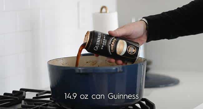 adding guinness beer to a pot with beef