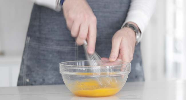 whisking together eggs in a bowl