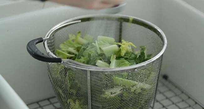 washing lettuce in a colander 