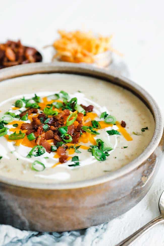 creamy potato soup in a bowl with cheese and green onions