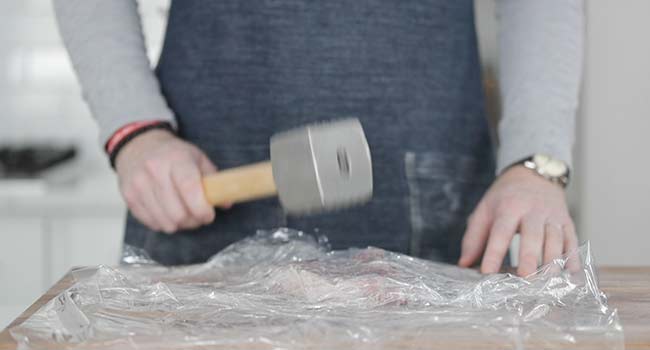 pounding and tenderizing a pork chop