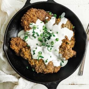 cast iron skillet with chicken fried steak and gravy