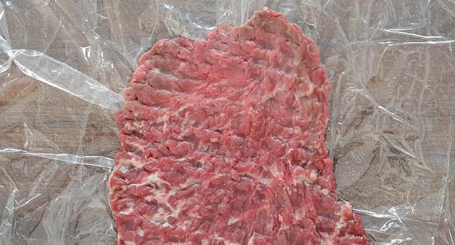 pounded cube steak on a cutting board