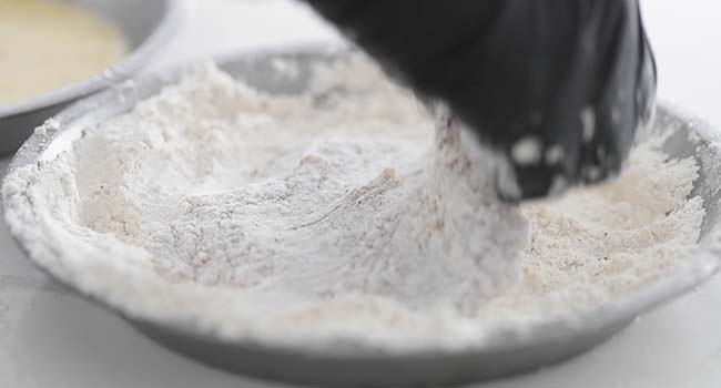 dredging a steak in a seasoned flour