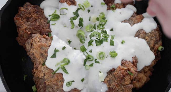 adding herbs to chicken fried steak with gravy