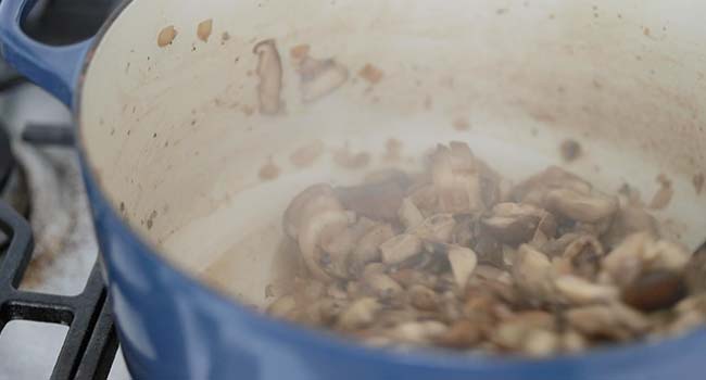 sauteing mushrooms in a large pot