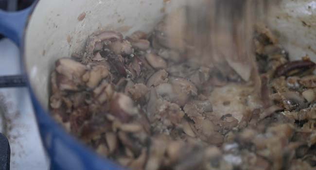 making a roux in a pot with cooked mushrooms