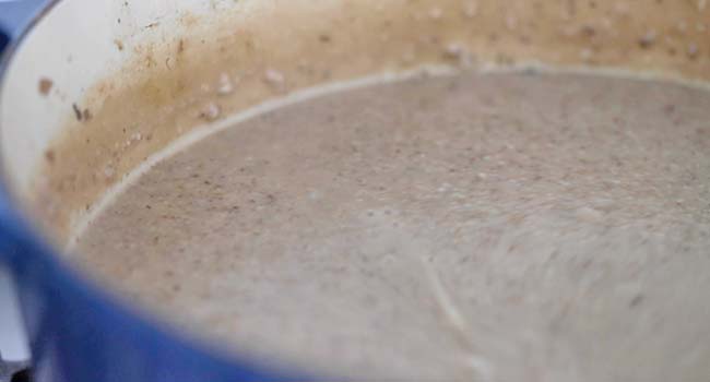 blending a mushroom soup with a hand blender