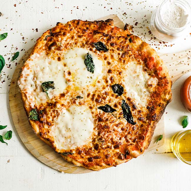 whole thin crust pizza with fresh basil