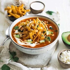 bowl of tortilla soup with crema and avocado