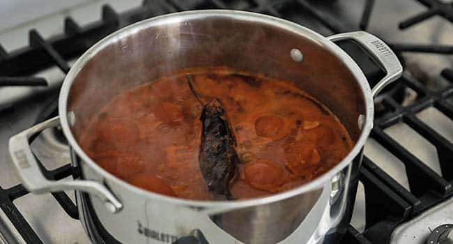 cooking tortilla soup with a pepper in a pot