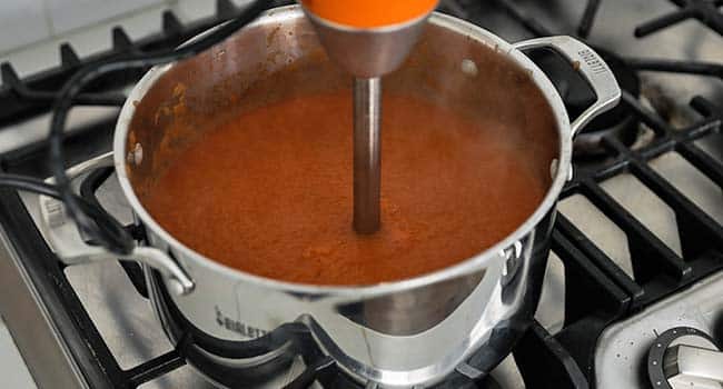 pureeing a tortilla soup with a hand blender