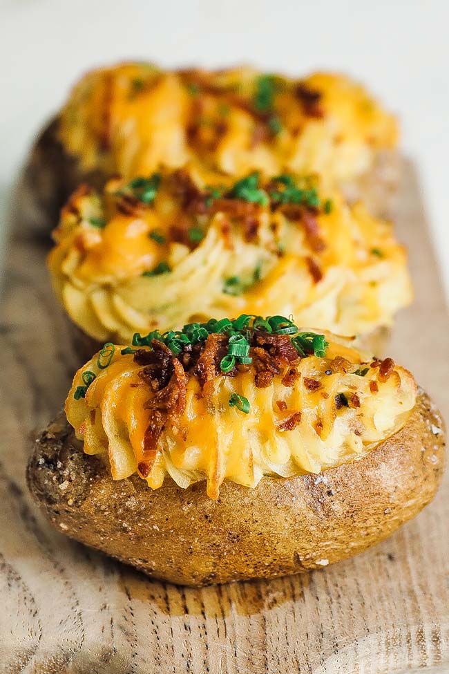 cooked twice baked potatoes on a cutting board