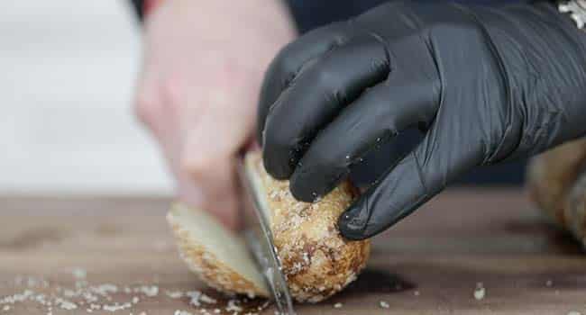 slicing a baked potato on a cutting board