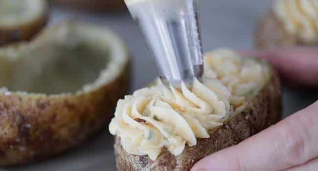 piping mashed potatoes into a potato skin shell