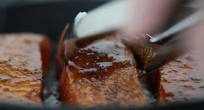 searing a blackened salmon in a pan