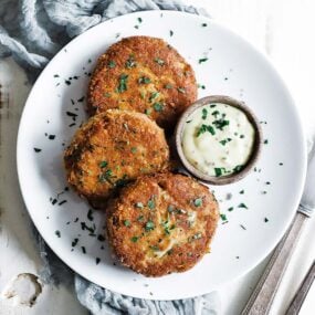 crab cakes on a plate with a mustard sauce