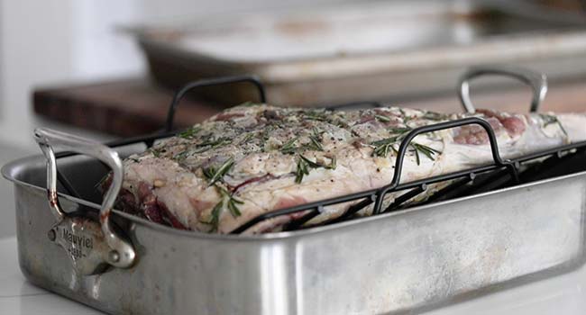 placing lamb leg in a roasting rack