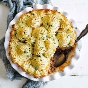 shepherd's pie in a white casserole dish with parsley