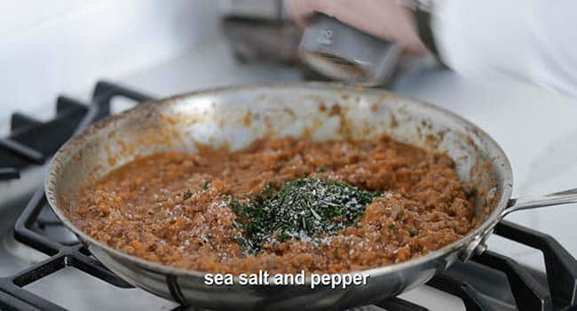 making shepherd's pie stuffing in a pan with herbs