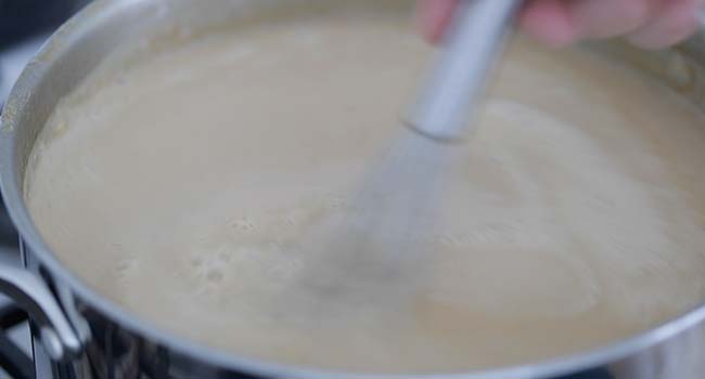 adding cream to a shrimp bisque