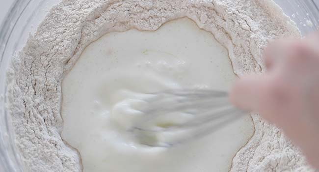 whisking together milk and flour in a bowl