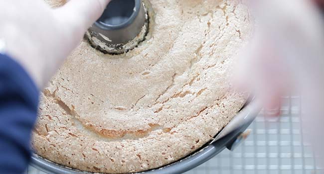 removing a baked angel food cake from a bundt pan