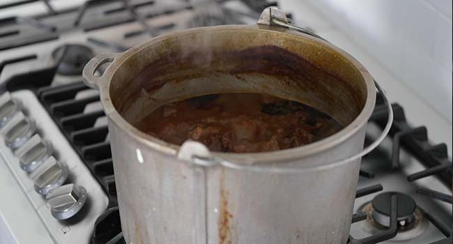 braising beef in a birria consome