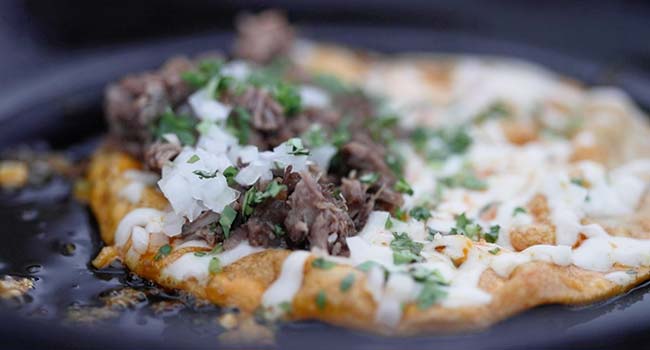 beef, cheese, and cilantro in a corn tortilla