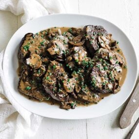 plate full of seared steak and mushroom sauce