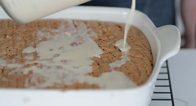 pouring milk onto a tres leches cake