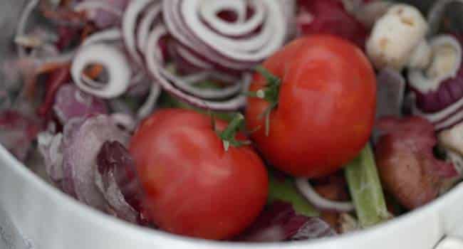 large tomatoes and veggie scraps in a pot