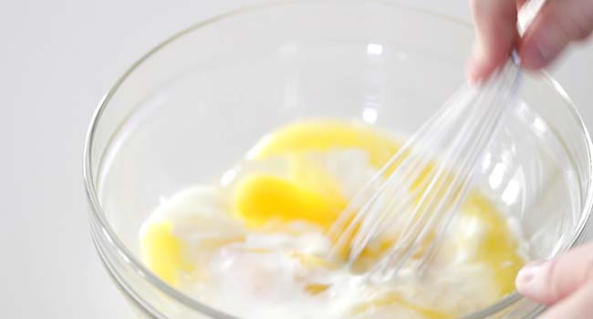 whisking together eggs and buttermilk in a bowl
