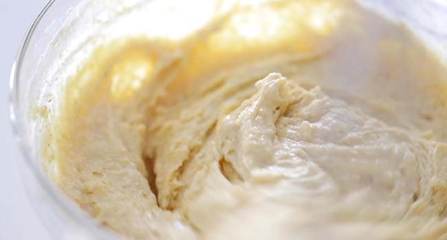 whisking together cornbread batter in a bowl