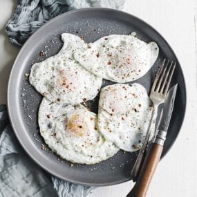 plate of fried eggs with salt and pepper