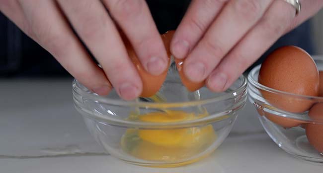 cracking an egg into a bowl