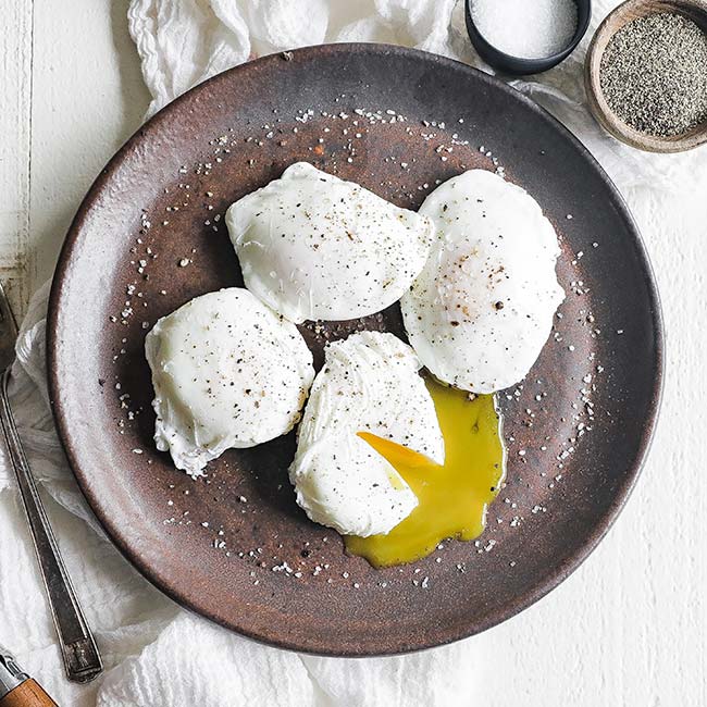 poached eggs with salt and pepper on a plate