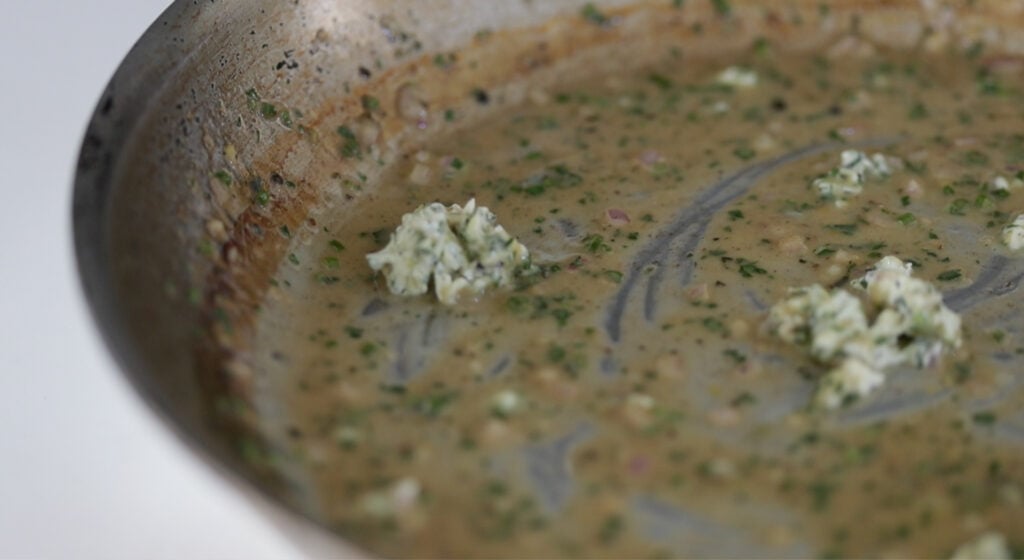 whisking butter into a pan