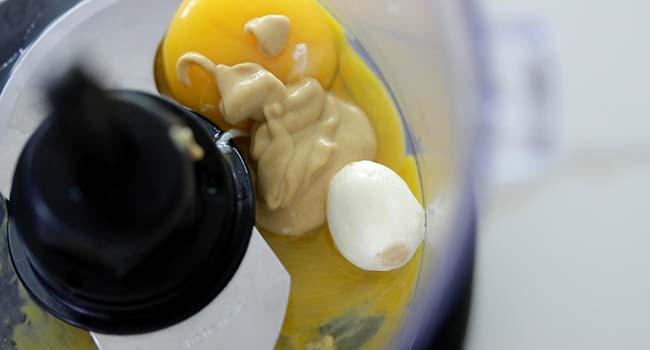 egg yolk with garlic and mustard in a food processor