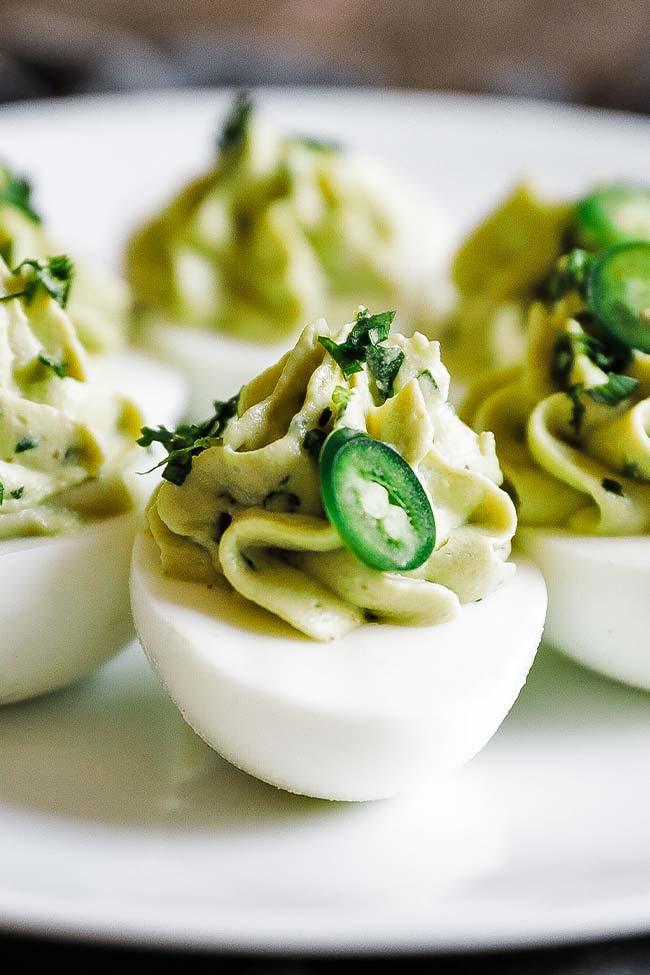 avocado deviled eggs with cilantro on a plate