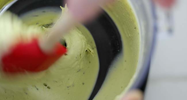 adding onion and cilantro to an avocado deviled egg filling