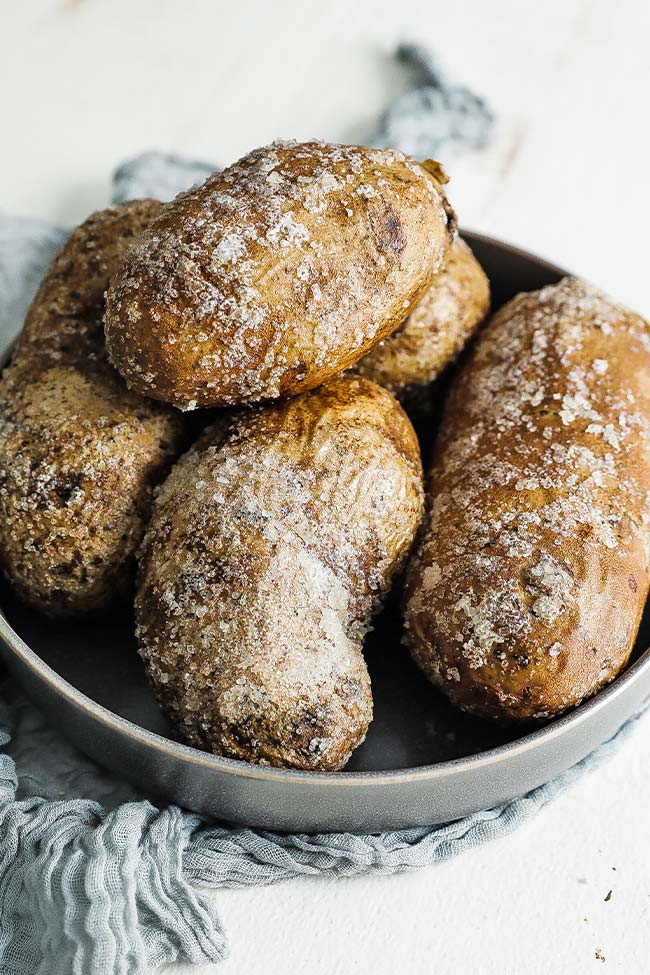 baked potatoes coated in salt in a bowl