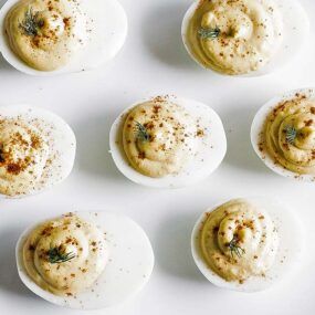 deviled eggs on a plate with paprika and dill