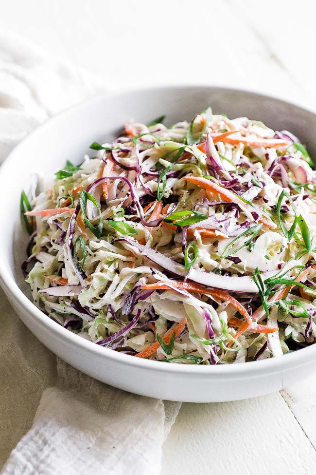 creamy coleslaw in a bowl with green onions